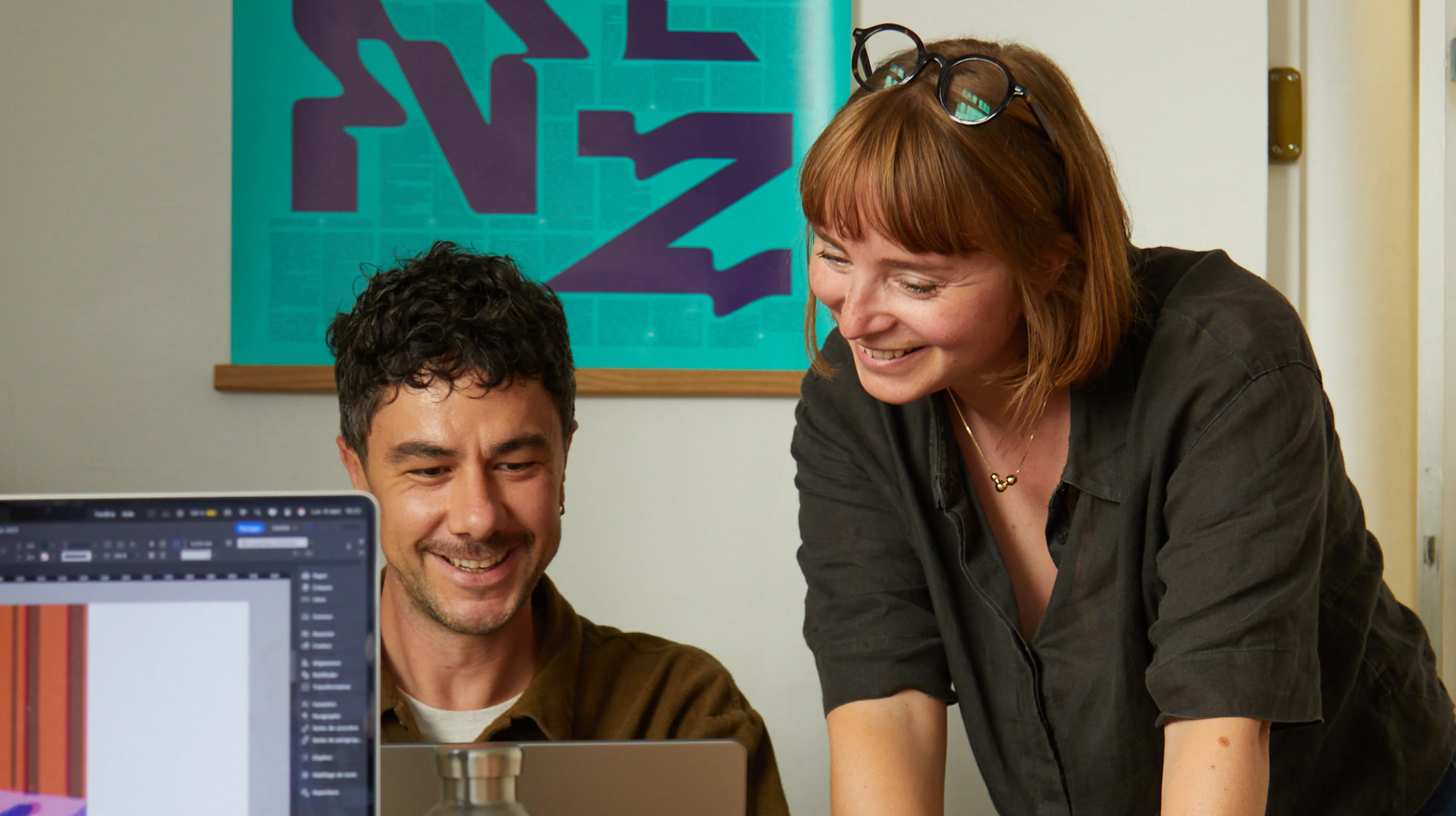 Louise et Jules, souriants et penchés sur un ordinateur